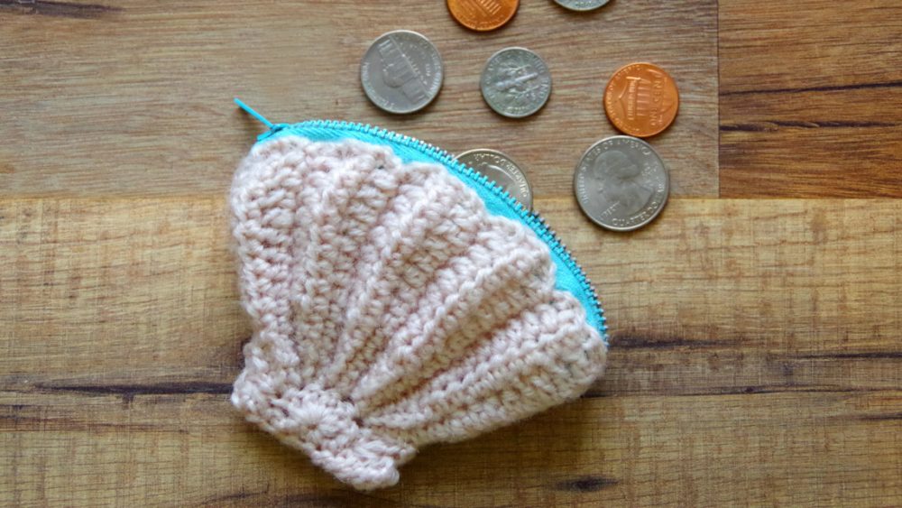 Seashell Coin Purse - These free crochet purse patterns are full of creative, adventurous ideas. Switch up your look or gift a friend one of these new crochet bags. #CrochetPursePatterns #CrochetPatterns #FreeCrochetPatterns