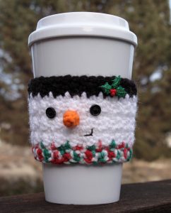 Crochet Snowman Coffee Cup Cozy - This list of free crochet patterns has some fun Christmas decorations that will deck your halls and bring jolly to your days! #crochetpatterns #christmascrochetpatterns #holidaycrochetpatterns