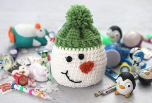 Crochet Snowman Sack With Stocking Stuffers - This list of free crochet patterns has some fun Christmas decorations that will deck your halls and bring jolly to your days! #crochetpatterns #christmascrochetpatterns #holidaycrochetpatterns