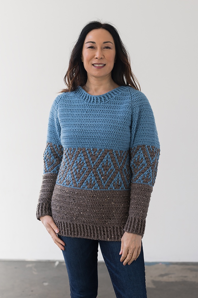 a woman wearing a landscape crochet sweater