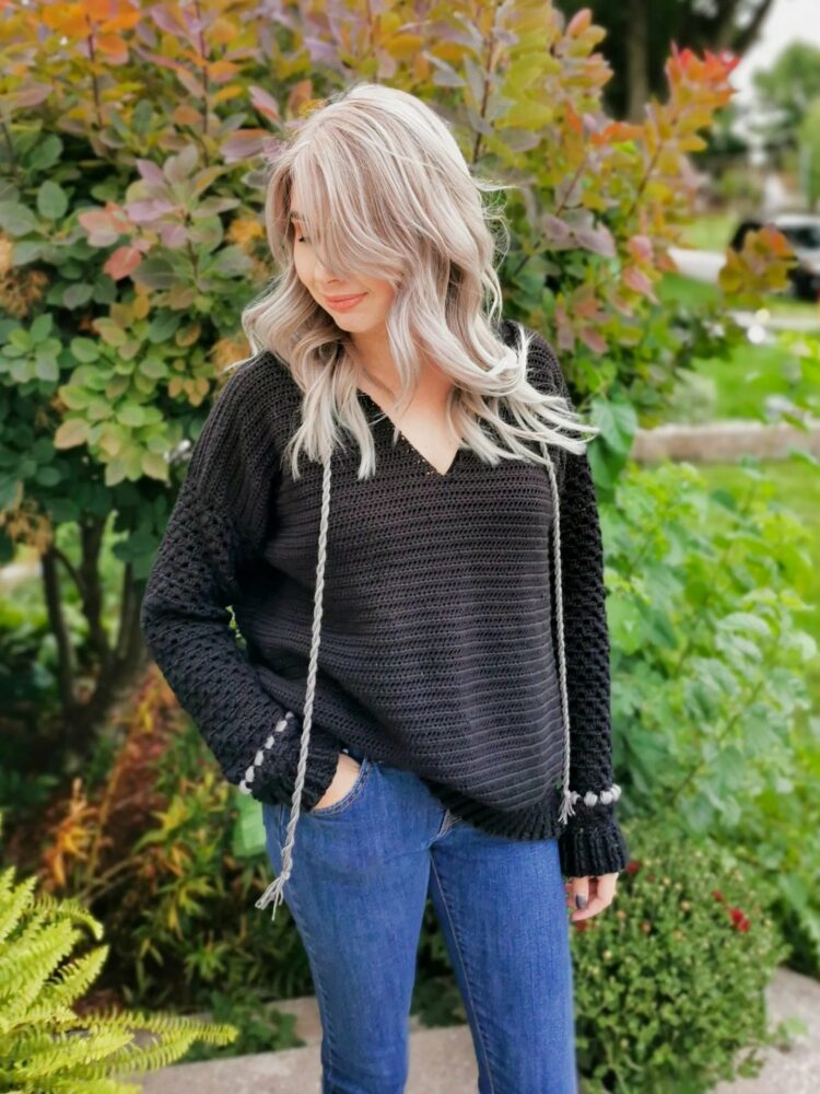 a woman wearing a crochet pullover sweater