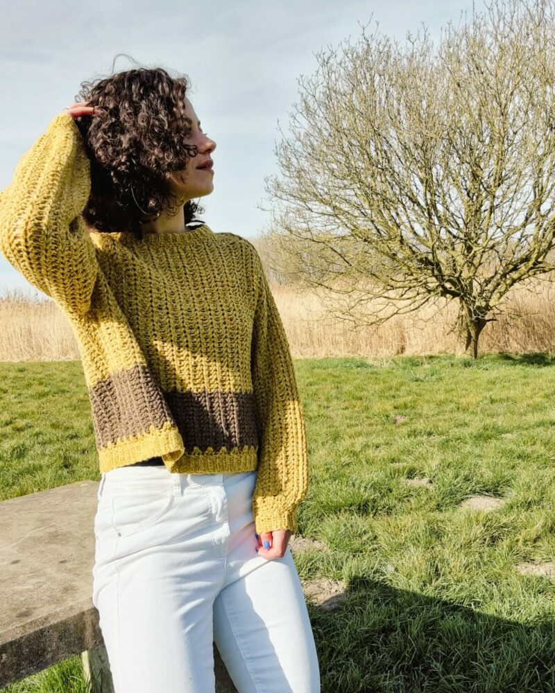 a woman wearing a yellow crochet sweater