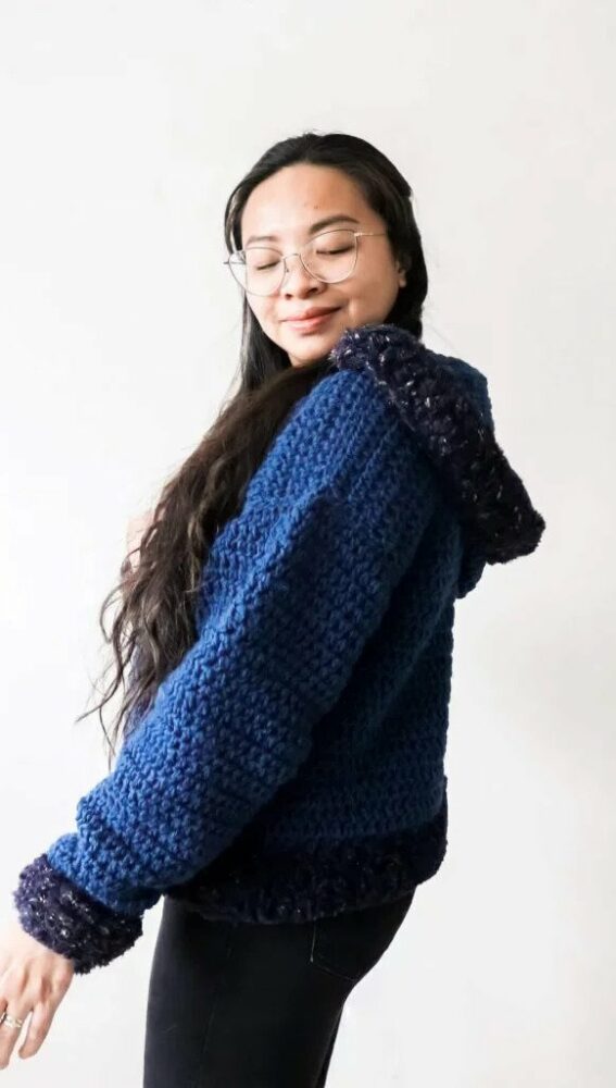 a woman wearing a pullover crochet hoodie