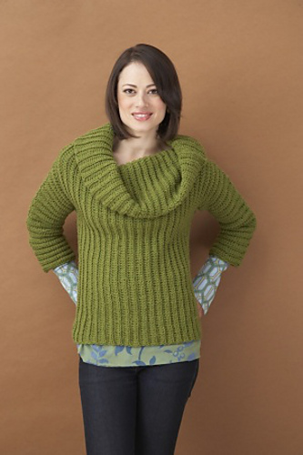 a woman wearing an olive cowl neck crochet sweater