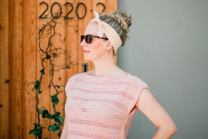 a woman wearing a sunglasses, a headband and a crochet top