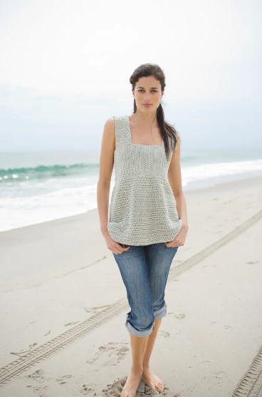 A girl in a beach wearing a crochet top
