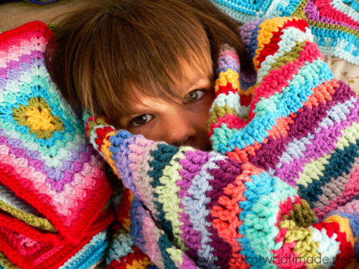 a child using a lazy waves crochet blanket