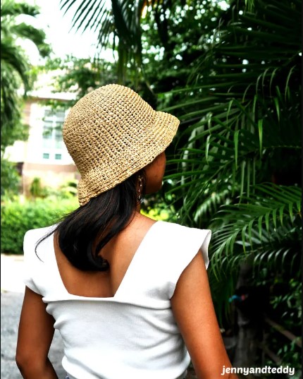 A woman wearing the Raffia Basic Crochet Bucket Hat
