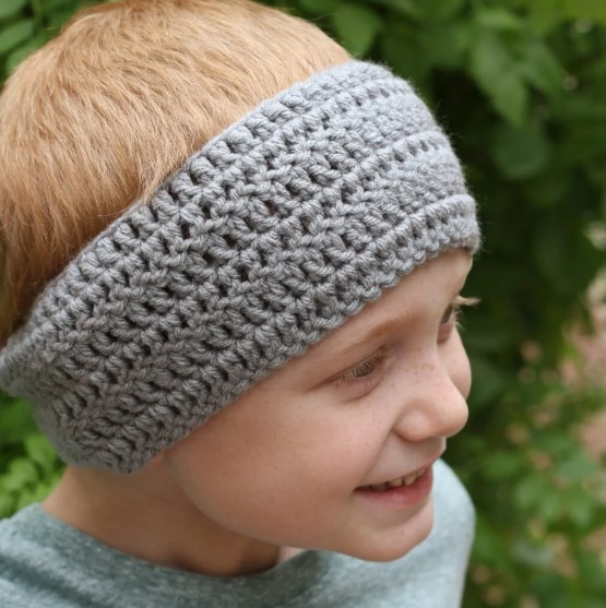 A boy wearing a crochet ear warmer 