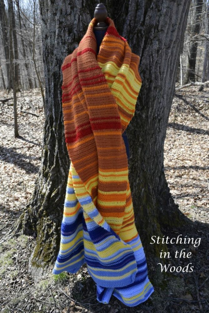 temperature crochet blanket in front of a tree in the woods