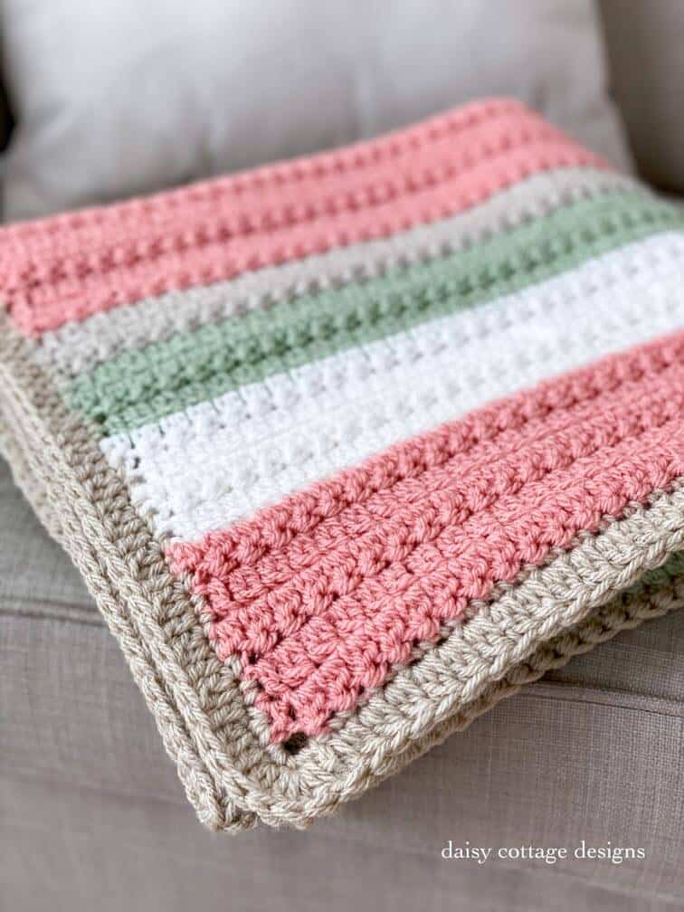 folded striped crochet blanket on a chair